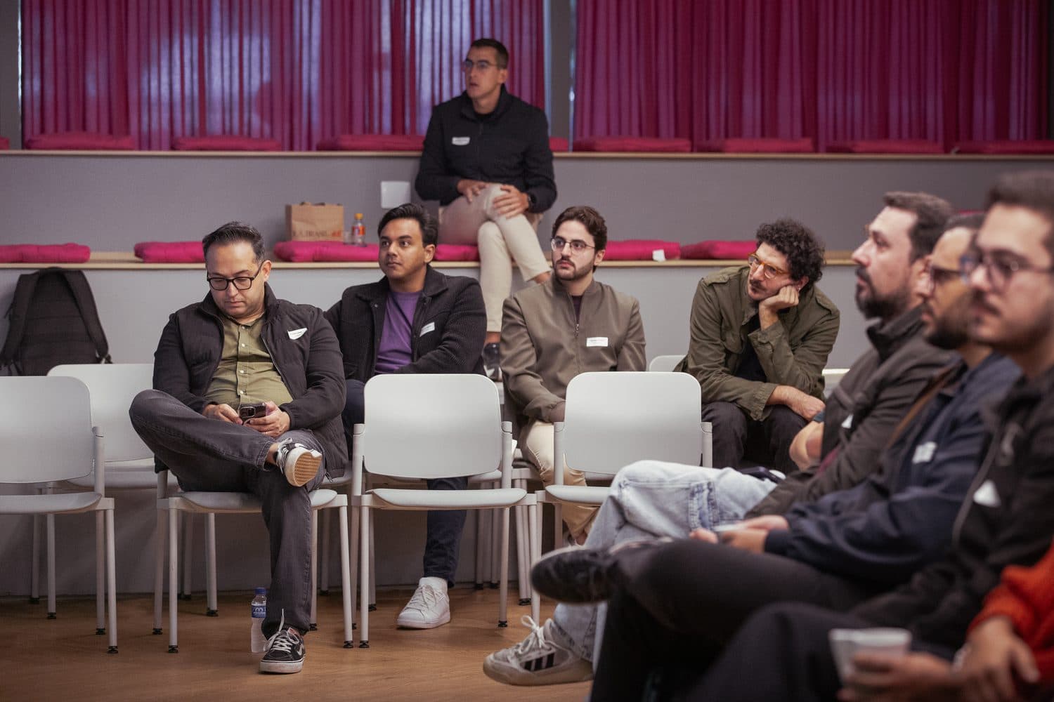 The room in a circle of chairs, listening to someone in the group.